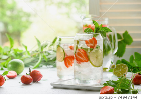 Homemade lemonade with soda, strawberries, and lim. 74947144