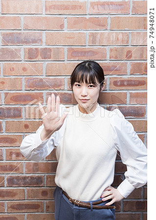 手のひらを突き出す女性 74948071