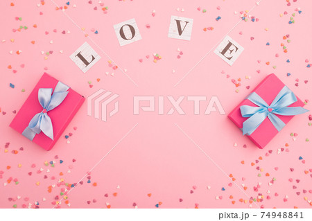 Composition with love inscription and gifts on pink background. Flat lay, top view. Composition with love inscription and gifts on pink background. Flat lay, top view. 74948841