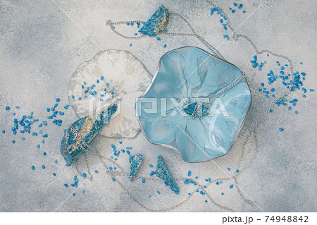 Composition with resin art plate and blue stones on gray background. Epoxy resin art. Flat lay, top view Composition with resin art plate and blue stones on gray background. Epoxy resin art. Flat lay, top view 74948842