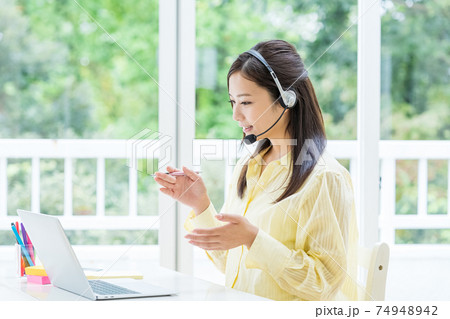 在宅で仕事するオペレーターの若い女性 在宅で仕事するオペレーターの若い女性 74948942