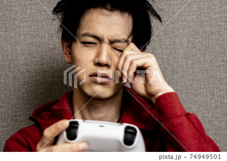 ビデオゲーム中毒の若い男性 寝癖のある若いアジア人男性 ゲームに狂った青年 の写真素材