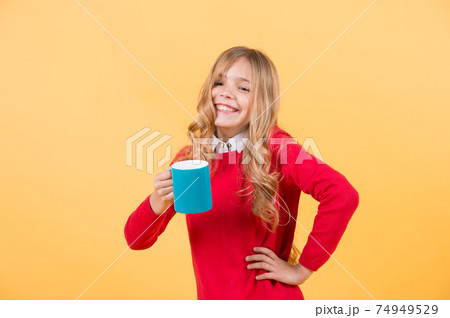 Girl with long blond hair in red sweater hold mug 74949529