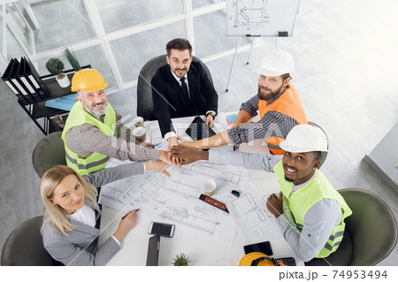 Partners gathering at office for creating plan of building 74953494