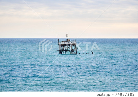 seascape with a rickety structure on the stilts of an aquaculture farm 74957385