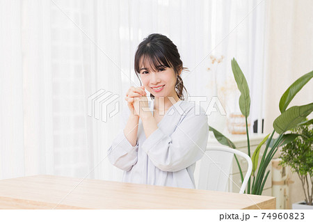 部屋でお願いのジェスチャーをする若い女性 部屋でお願いのジェスチャーをする若い女性 74960823