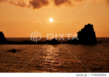 夕日の名所　新潟県　能生海岸　弁天岩　夏の夕日 74960868