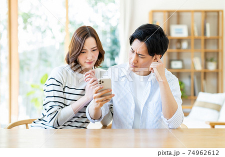 スマホで悩む若い夫婦 74962612