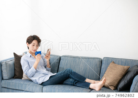 クレジットカードとスマートフォンを持つ女性 クレジットカードとスマートフォンを持つ女性 74962802