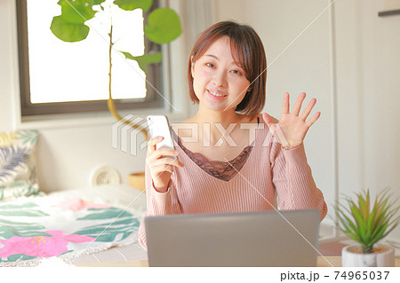 スマホを持ち呼び掛ける女性 スマホを持ち呼び掛ける女性 74965037