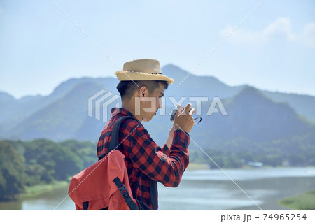 Young man photographing with vintage camera Young man photographing with vintage camera 74965254