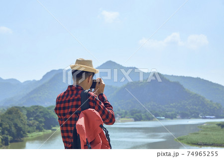 Young man photographing with vintage camera 74965255