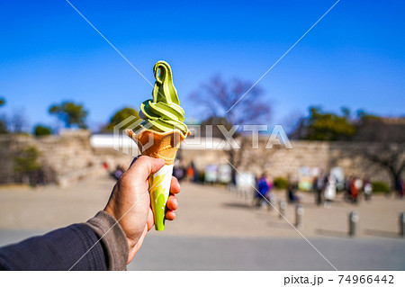 green tea icream cone in man hand with blur background, Japan 74966442