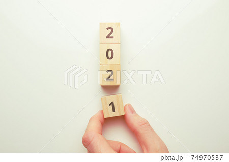 The concept of the transition to the new year 2021. Hand holds a wooden block. The concept of the transition to the new year 2021. Hand holds a wooden block. 74970537