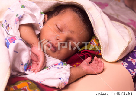 Close up face of cute sleeping newborn baby boy in drowsy eyes with sleepy mood. One month old Sweet infant toddler Closeup portrait. Indian ethnicity. Front view. Child care peace tranquil background 74971262