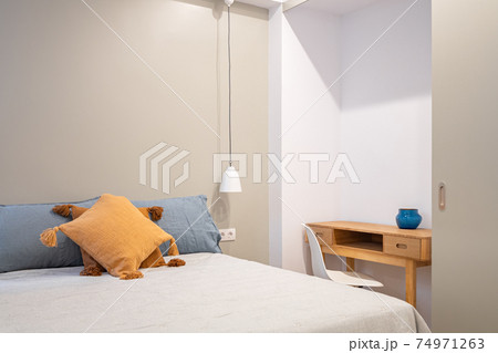 Interior of modern bedroom with small table and chair. Bright room with pleasant and calm colors. Interior of modern bedroom with small table and chair. Bright room with pleasant and calm colors. 74971263