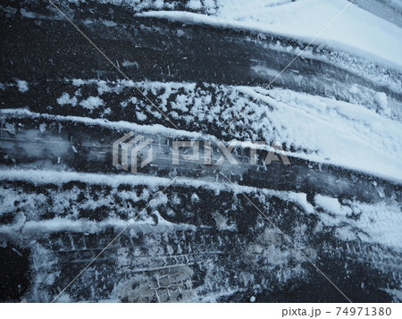 氷った雪道のタイヤの跡　危険なアイスバーンとタイヤの跡 74971380