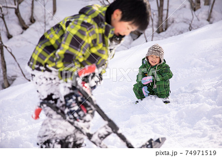 スキー場でスキーウェアーを着て兄弟で遊んでいる winter スキー場でスキーウェアーを着て兄弟で遊んでいる winter 74971519