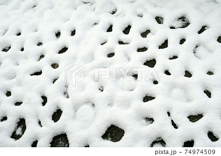 石畳に積もった雪の溶け出した模様の写真素材
