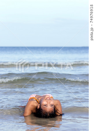A young woman lying in the sea 74976918