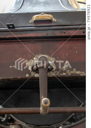 An old antique car with a hand crank for start, close up. An old antique car with a hand crank for start, close up. 74976921