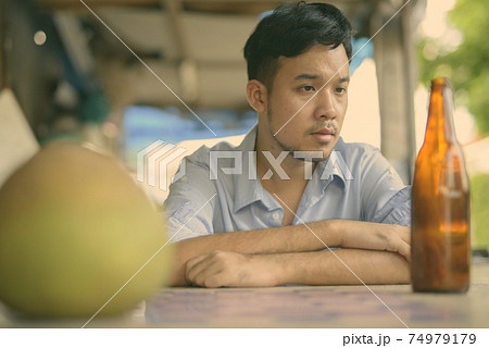 Young Asian businessman drinking beer in the streets outdoors Young Asian businessman drinking beer in the streets outdoors 74979179