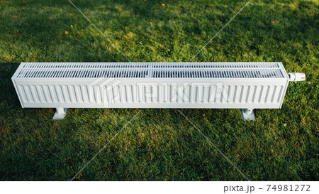 radiator on green lawn, ecological heating concept radiator on green lawn, ecological heating concept 74981272