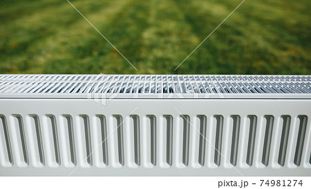 radiator on green lawn, ecological heating concept radiator on green lawn, ecological heating concept 74981274