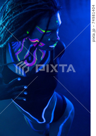 Cocky Girl with Dreadlocks in Ultraviolet neon light with Foggy Background. Bodyart Cocky Girl with Dreadlocks in Ultraviolet neon light with Foggy Background. Bodyart 74981404
