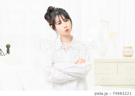 部屋で腕組みをしている白いシャツを着た若い女性 部屋で腕組みをしている白いシャツを着た若い女性 74983221