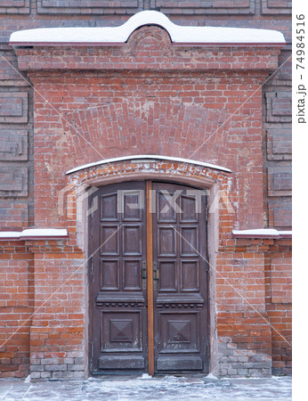 old wooden entrance doors. massive door in a brick building. old wooden entrance doors. massive door in a brick building. 74984516