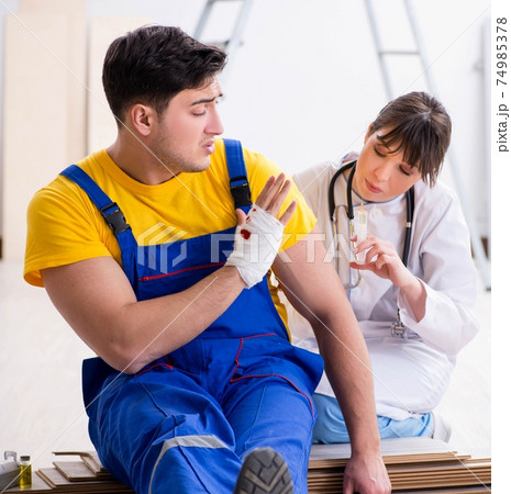 Injured worker being assisted by doctor Injured worker being assisted by doctor 74985378