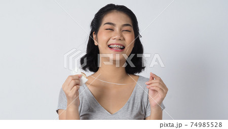 Dental brace teen girl smiling looking on a camera. white teeth with blue braces. Dental care. Asian woman smile with orthodontic accessories. Cosmetic dentistry, orthodontics treatment. Oral braces.. Dental brace teen girl smiling looking on a camera. white teeth with blue braces. Dental care. Asian woman smile with orthodontic accessories. Cosmetic dentistry, orthodontics treatment. Oral braces.. 74985528