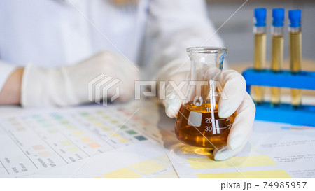 Woman making urine test with ph material in laboratory Woman making urine test with ph material in laboratory 74985957