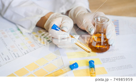 Woman making urine test with ph material in laboratory Woman making urine test with ph material in laboratory 74985959
