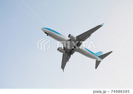 flying airplane in blue sky 74986395