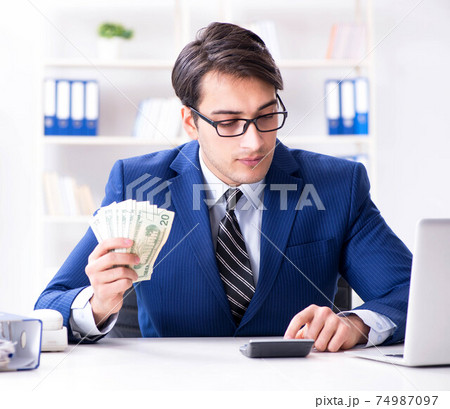 Accountant calculating dollars with calculator in office 74987097