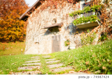 Stone path in front of blurred traditional italian house in countryside. Stone path in front of blurred traditional italian house in countryside. 74987424