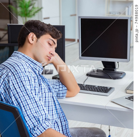 Businessman sitting in front of many screens 74988019