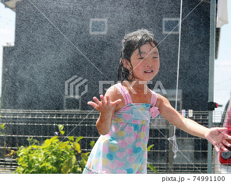 庭で水遊びする女の子の写真素材