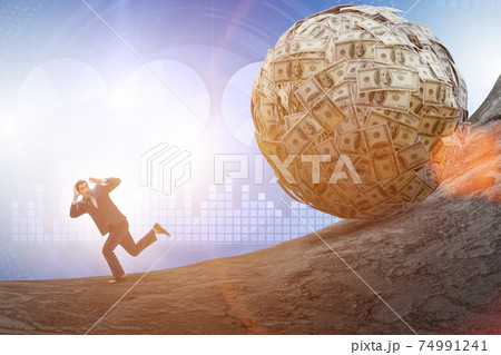 Businessman running away from dollar ball 74991241