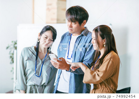 スマホを見る男女の会社員 74992454