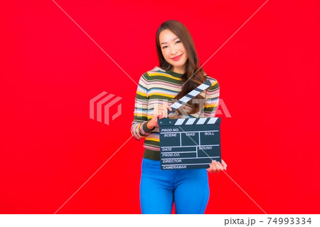 Portrait beautiful young asian woman with movie slate cutting Portrait beautiful young asian woman with movie slate cutting 74993334