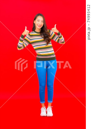 Portrait beautiful young asian woman smile with action on red background 74993412