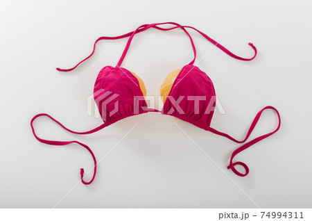 Pumpkin bra on a white background. Two pumpkins in a bikini. Copy space Pumpkin bra on a white background. Two pumpkins in a bikini. Copy space 74994311