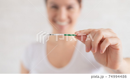 Happy woman shows a positive pregnancy test. The concept of female fertility. Human chorionic gonadotropin. Two stripes expecting a baby. 74994486