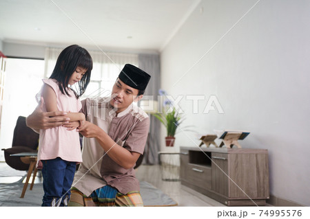 muslim father teaching her daughter how to pray at home muslim father teaching her daughter how to pray at home 74995576