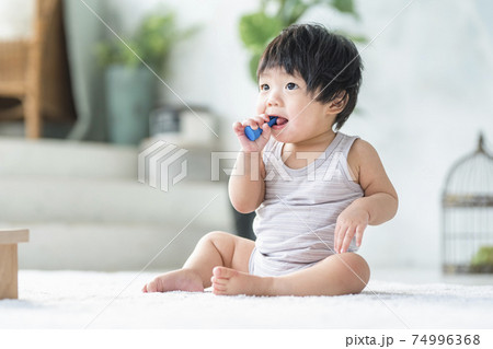 木のおもちゃで遊ぶ0歳の赤ちゃんの写真素材