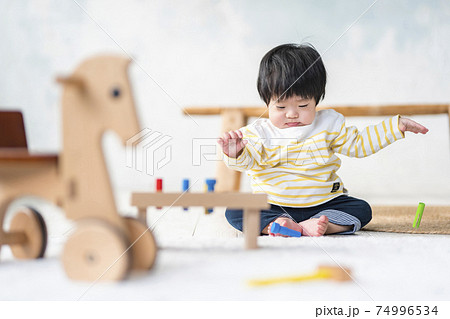 木のおもちゃで遊ぶ0歳の赤ちゃんの写真素材