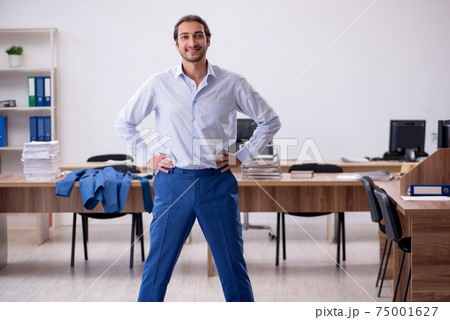Young male employee doing sport exercises during break Young male employee doing sport exercises during break 75001627